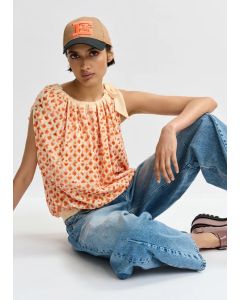 Top asymétrique à paillettes et nœud orange